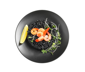 Delicious black risotto with shrimps and lemon isolated on white, top view