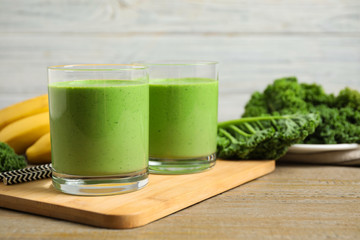 Tasty fresh kale smoothie on wooden table