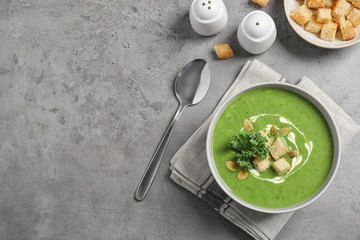 Tasty kale soup with croutons served on grey table, flat lay. Space for text