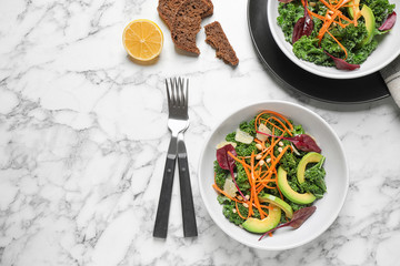 Tasty fresh kale salad on marble table, flat lay. Space for text