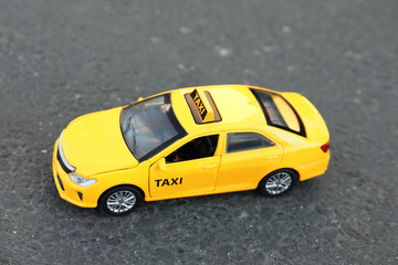 Yellow taxi car model on city street