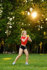 A young girl goes in for sports with dumbbells in nature. fitness woman workout outdoors in the park.