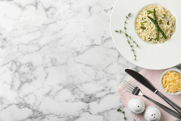 Delicious risotto with asparagus served on marble table, flat lay. Space for text