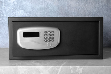 Obraz premium Black steel safe with electronic lock on grey marble table
