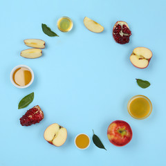 Flat lay composition with honey and fruits on light blue background, space for text. Rosh Hashanah holiday