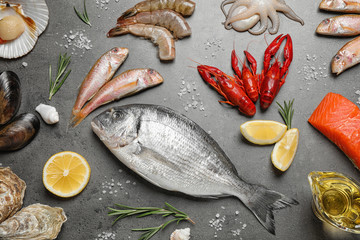 Fresh fish and seafood on grey table, flat lay
