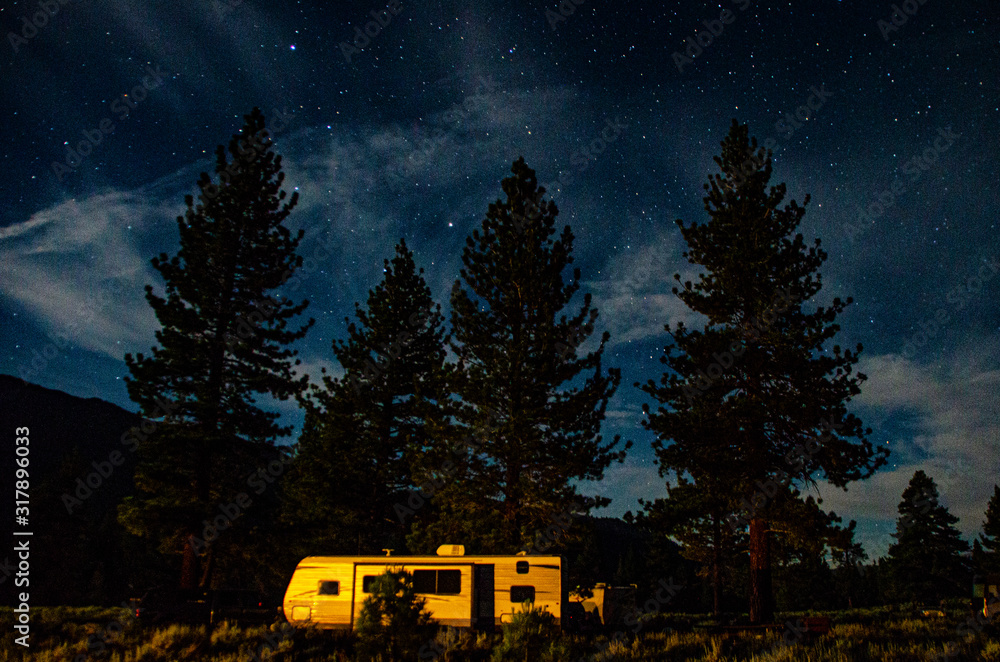 Wall mural Lonely campervan in the nature under an amazing sky full of stars, California, USA