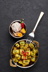 Aloo Methi in copper kadai, bowl at dark slate background. Aloo Methi is indian cuisine dish with Potato, Fenugreek and Spices. Indian Food. Top view