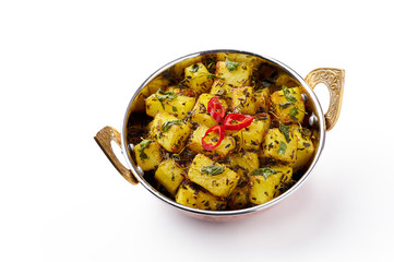 Aloo Methi in copper kadai, bowl isolated at white background. Aloo Methi is indian cuisine dish with Potato, Fenugreek and Spices. Indian Food. Isolate