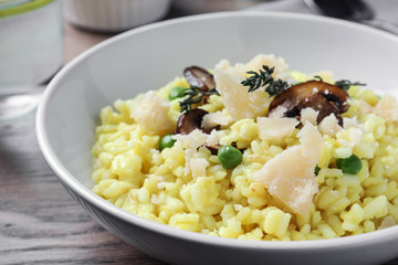 Delicious risotto with cheese and mushrooms on wooden table, closeup