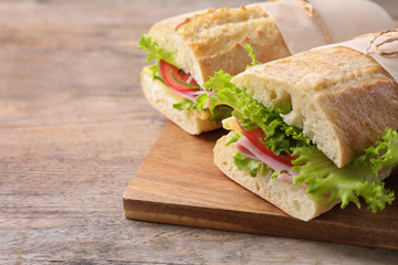Tasty sandwiches with ham on wooden table, closeup