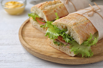 Tasty sandwiches with ham on white wooden table, closeup