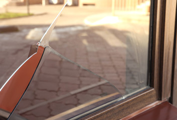 Broken window with sharp smithereens outdoors. Requiring repair