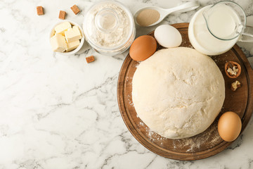 Flat lay composition with dough for pastries on white marble table. Space for text