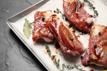 Raw marinated ribs on black table, closeup