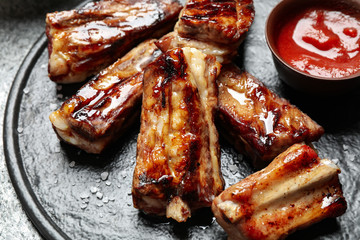 Delicious grilled ribs on board, closeup view
