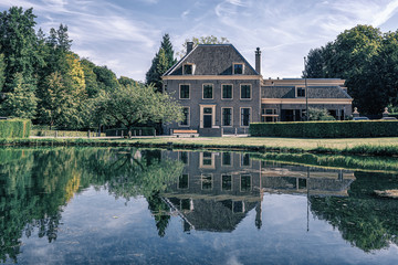 Fototapeta premium Beautifull country house with a reflection in the pond of the park Rozendael castle