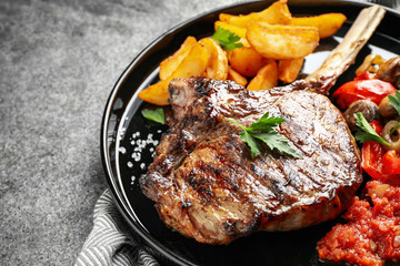 Delicious grilled ribeye served on grey table, closeup