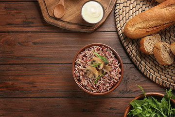 Fototapeta na wymiar Delicious brown rice served on wooden table, flat lay