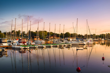 Boats docking in the marina at the Niegocin Lake during sunrise. Wilkasy, Masuria , Poland. - obrazy, fototapety, plakaty