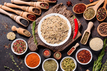 Spices and herbs over black stone background. Top view with free space for menu or recipes