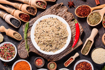 Spices and herbs over black stone background. Top view with free space for menu or recipes