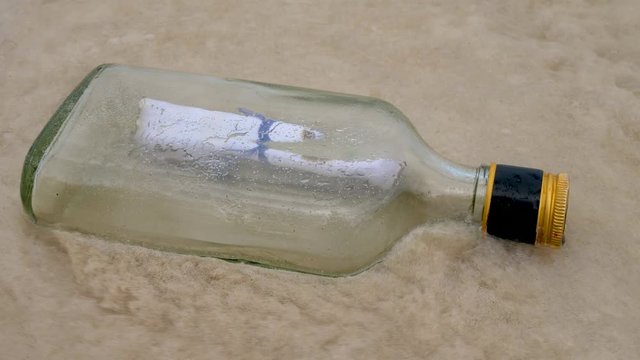 Message In Bottle floating In Ocean Water on Coast