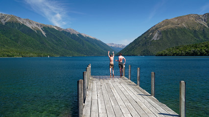 Boys jumping off the jetty at Lake Rotoiti, Nelson Lakes National Park, New Zealand.