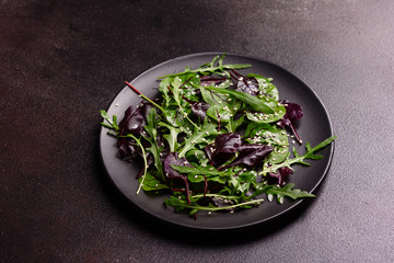 Healthy food, salad mix with arugula, spinach, bulls blood, beet leafs and micro greens