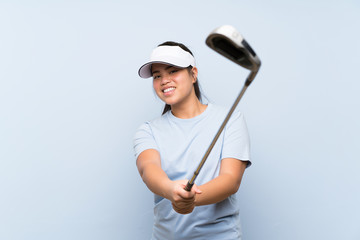 Young golfer Asian girl over isolated blue background