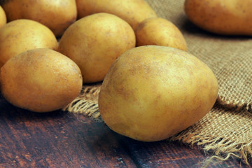 Potato and sack on a wooden table