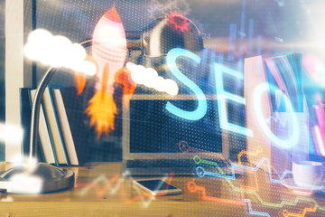 Multi exposure of table with computer and seo drawing hologram. Search optimization concept.