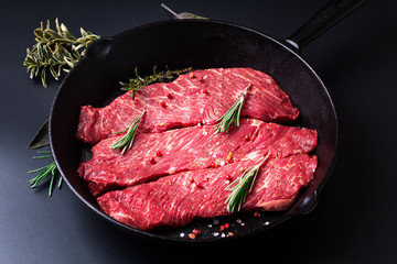Food concept organic raw meat filet beef steak in skillet iron pan on black background