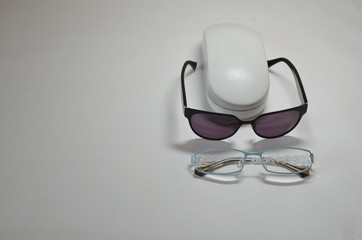  Optics. On a white background, a case for white glasses, sunglasses and glasses with transparent glasses to improve vision.