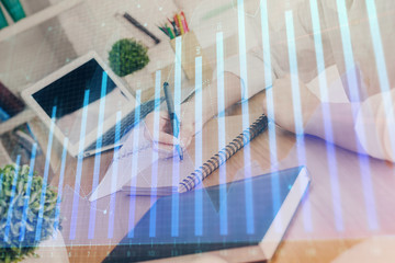 Financial graph displayed on woman's hand taking notes background. Concept of research. Double...