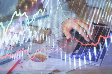 Forex graph with businessman working on computer in office on background. Concept of hardworking....