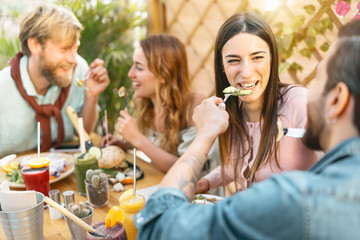 Happy friends lunching with healthy food in bar restaurant - Young people having brunch meal eating and drinking smoothies fresh fruits in vintage bar -  Health trends lifestyle concept