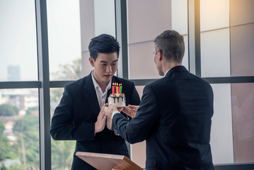 Boss surprise singing to company employee celebrate birthdays with birthday cake and there were candles on the cake party in meeting room