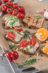 Mini canapes with cheese, tomatoes and tangerines