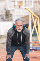 A senior adult taking a breath at the basketball court.