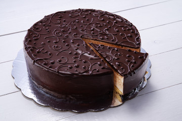 Chocolate cake with decoration isolated over wooden background
