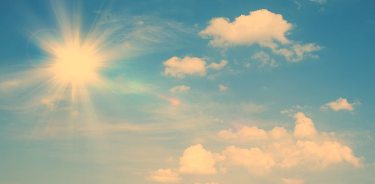 Sunny natural background, blue sky with sun and white clouds vintage background.