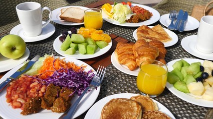Woman Having Breakfast With Orange Juice, Fruits, Pancakes And Croissants.