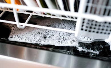 Excess detergent at the bottom of the dishwasher after washing. Foam