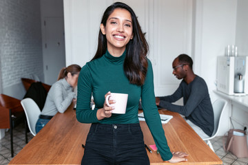 Young indian business woman entrepreneur looking at camera in the office.
