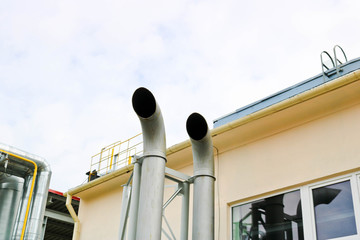 Two large metal tall pipes for the emission of gases and smoke at an industrial refinery petrochemical chemical plant