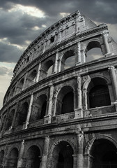 Obraz premium Black and White Colosseum in Rome whit dramatic cloud sky in the background.