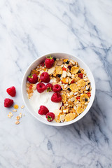 Healthy breakfast. Fresh granola, muesli with yogurt and berries on marble background. Top view....