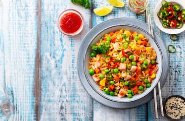 Asian fried rice, Cantonese cuisine. Blue wooden background. Top view. Copy space.