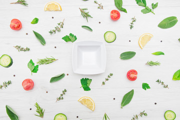 top view of various types of aromatic herb leaves and cut vegetables on wooden background